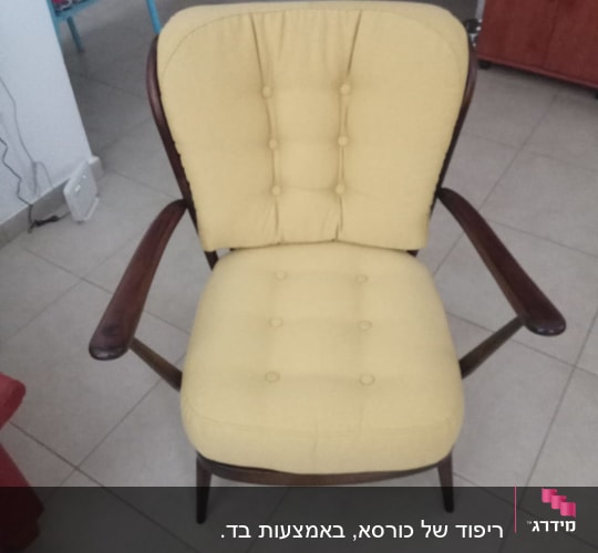 כיסא מרופד בצבע צהוב עם ידיות עץ